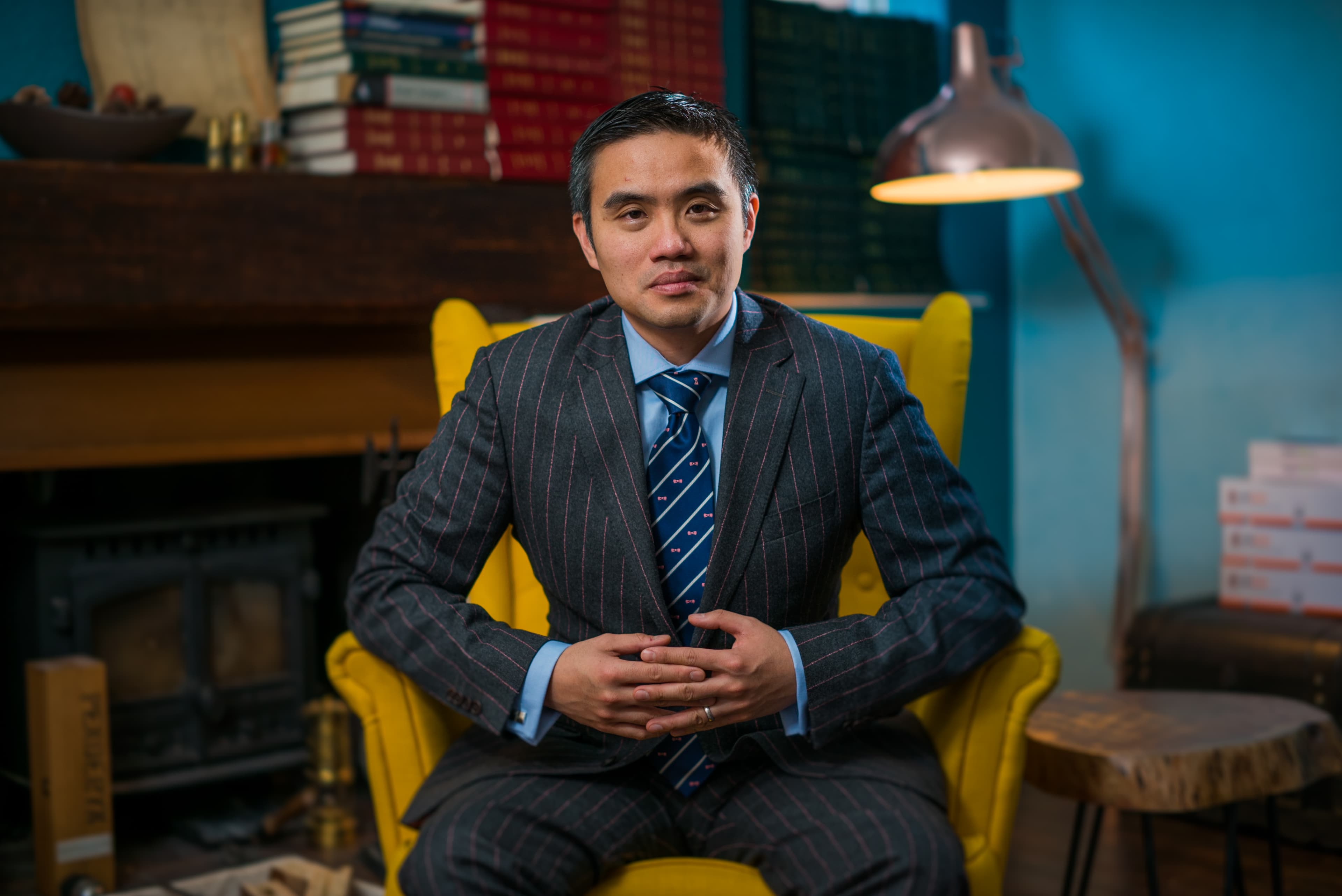Professor Paul Lee seated in a yellow armchair, a portrait setting for the interview